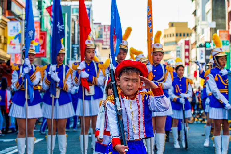 Boy And Women Holding Flags Marching On The Street