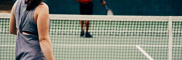 Two players on court during a Neighborhood Tennis camp session