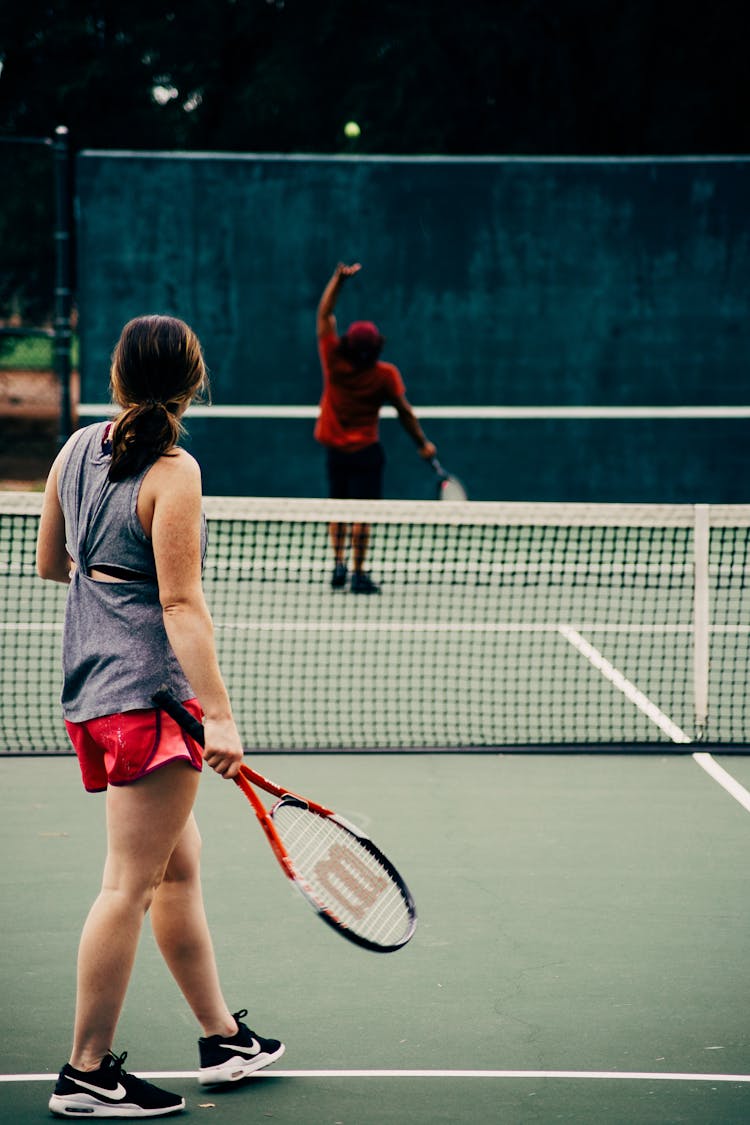 Man And Woman Playing Tennis Together