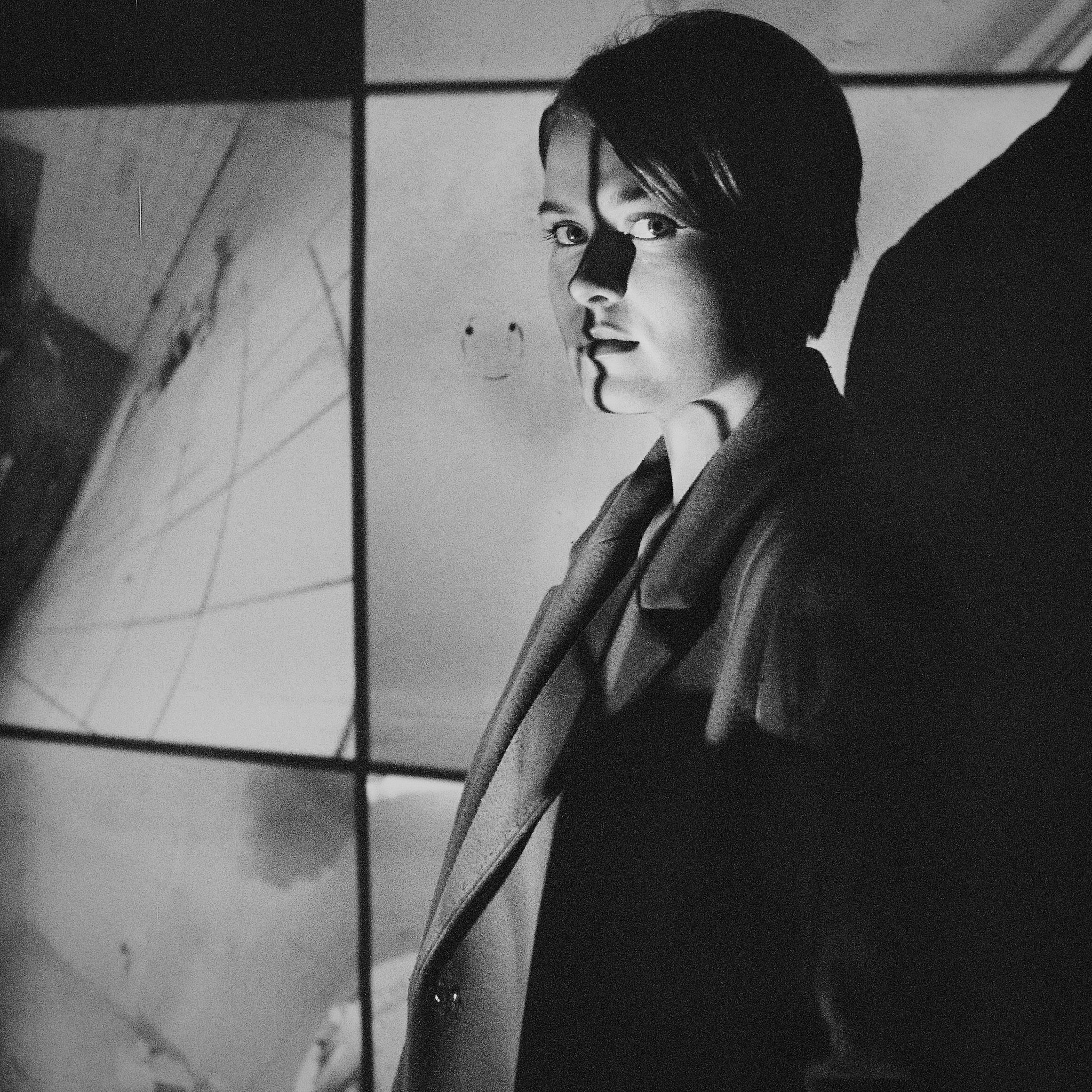 Grayscale Photo of Woman Sitting on the Window · Free Stock Photo
