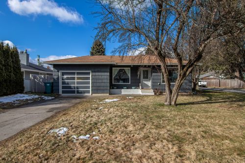 Free A quaint suburban house with a tree-lined front yard on a crisp, sunny day. Stock Photo