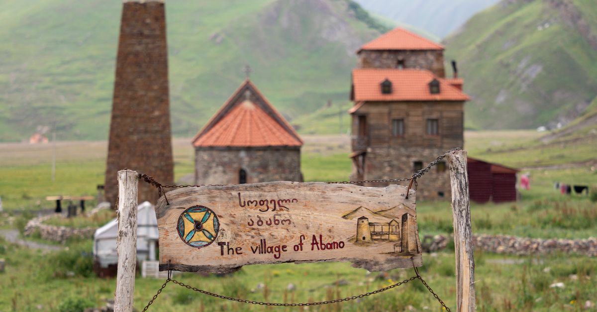 Rustic wooden sign of the village of Abano with stone towers in scenic Ketrisi, Georgia.