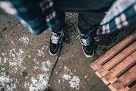 白雪皑皑的城市人行道上，放着一双时尚运动鞋，旁边是一个木箱