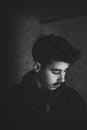 一位年轻人的黑白艺术肖像以侧面视角呈现，流露出喜怒无常又内省的氛围