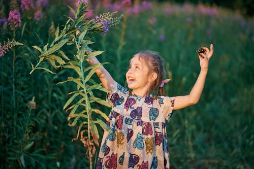 A Girl in Printed Dress Collecting Grass Flowers