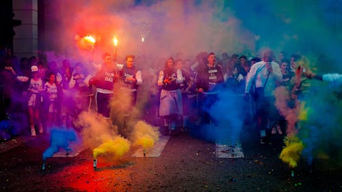 Grupo De Personas En La Carretera Con Humo De Varios Colores