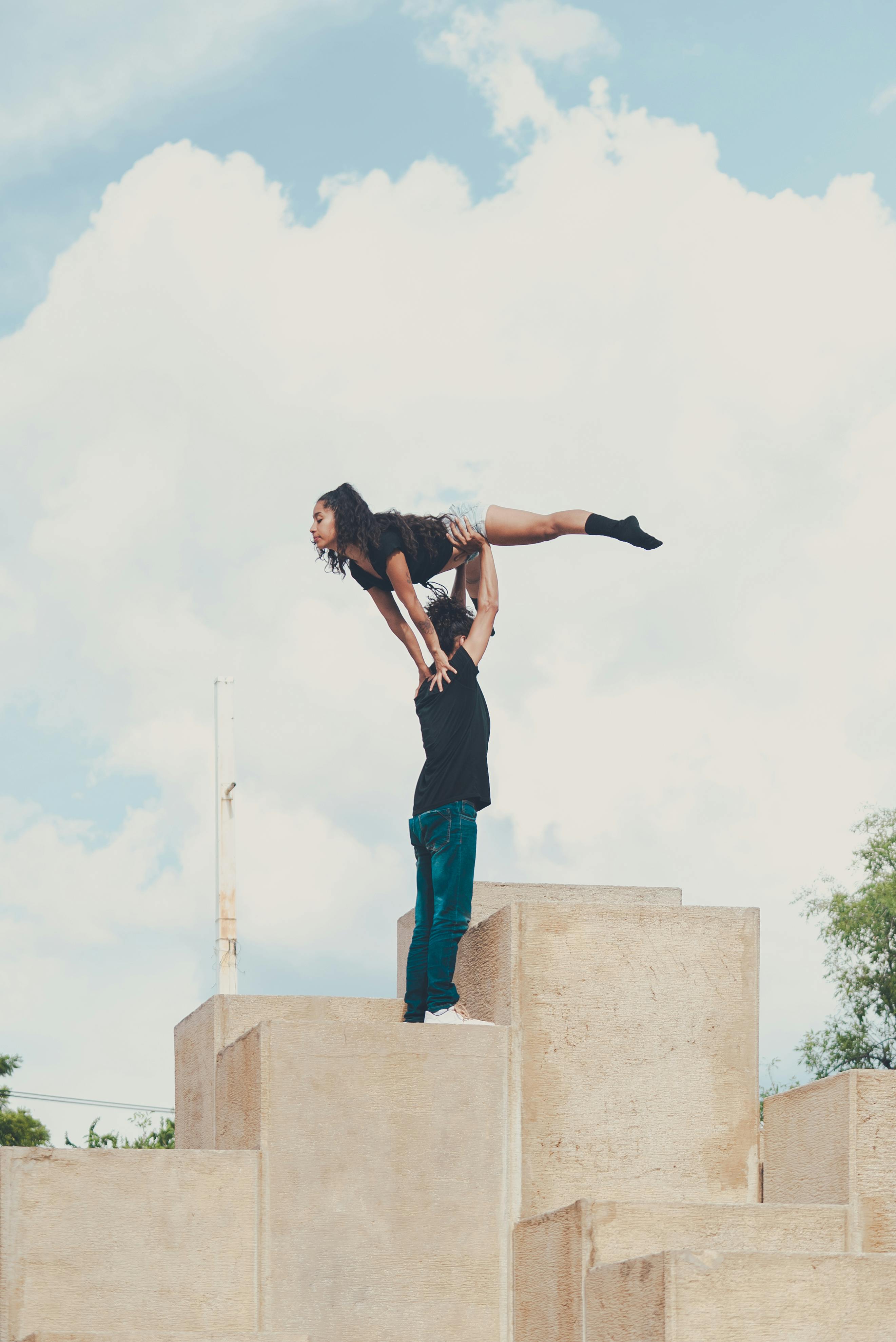 man lifting woman under a blue sky