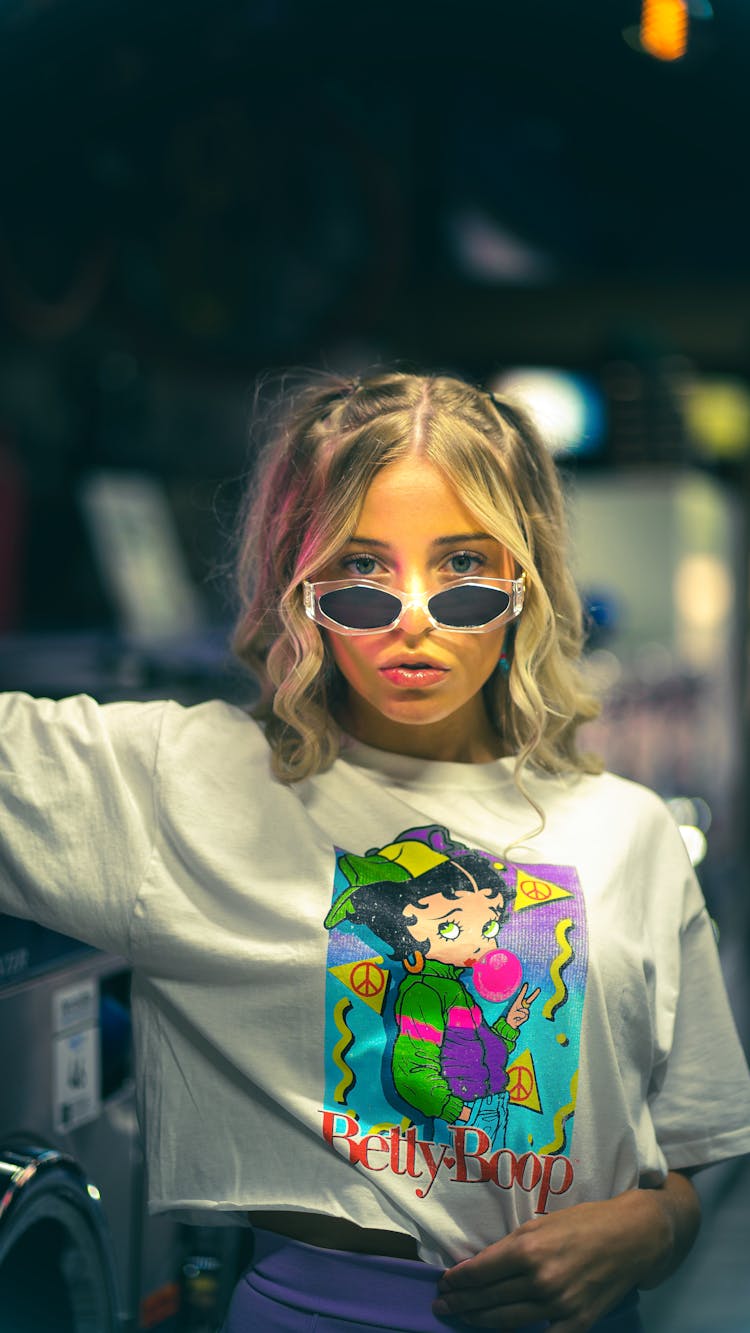 Young Woman In Sunglasses Standing In Laundromat