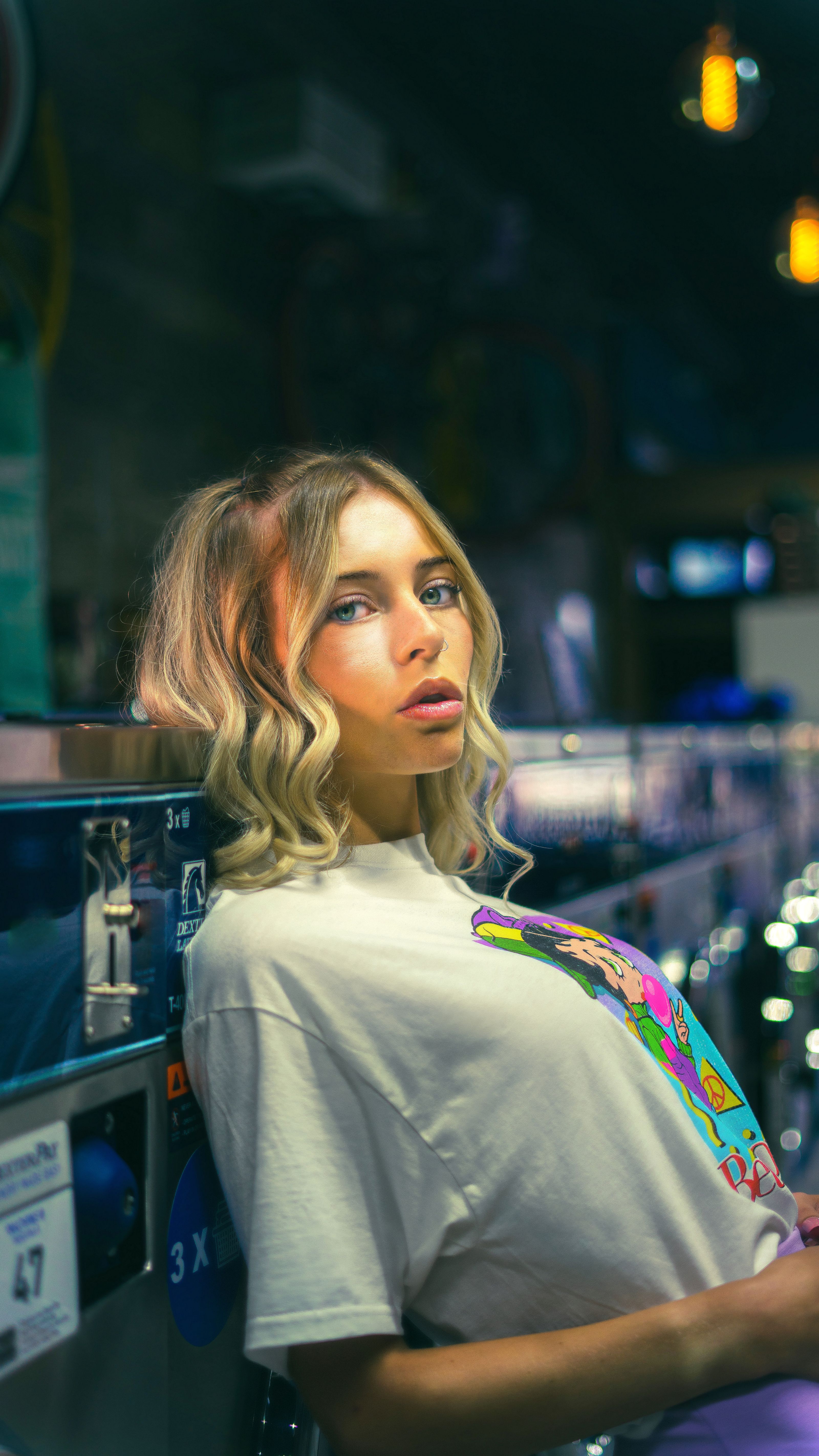 Uma jovem fashionista com cabelo cacheado se inclina pensativa em uma lavanderia chique, incorporando modernidade estilosa.