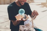 A Man Holding Round Objects to Juggle