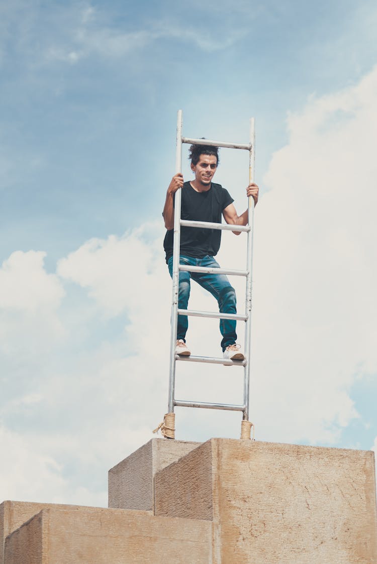 A Man Balancing On A Ladder