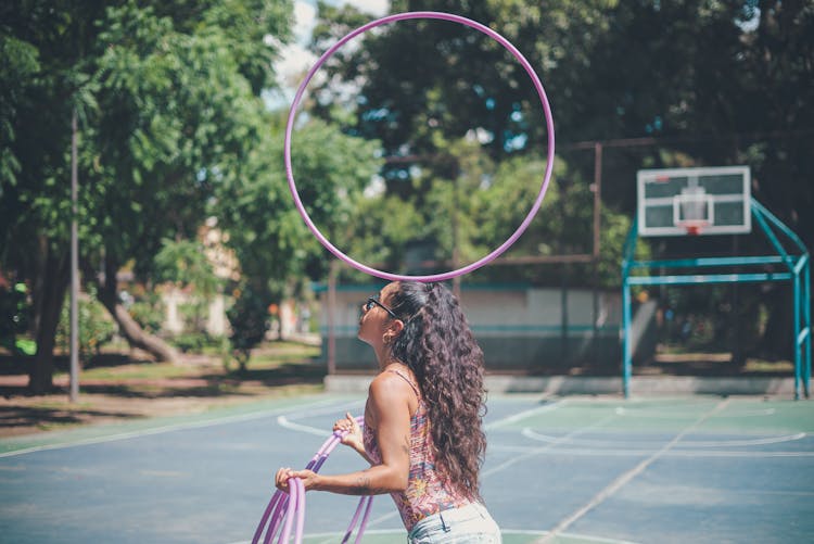 A Woman Balancing A Hula Hoop Over Her Head