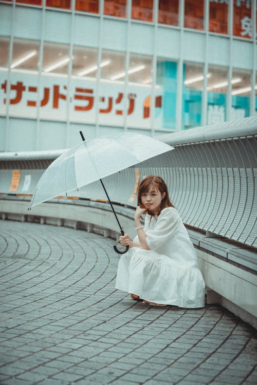 Woman in White Dress Holding an Umbrella