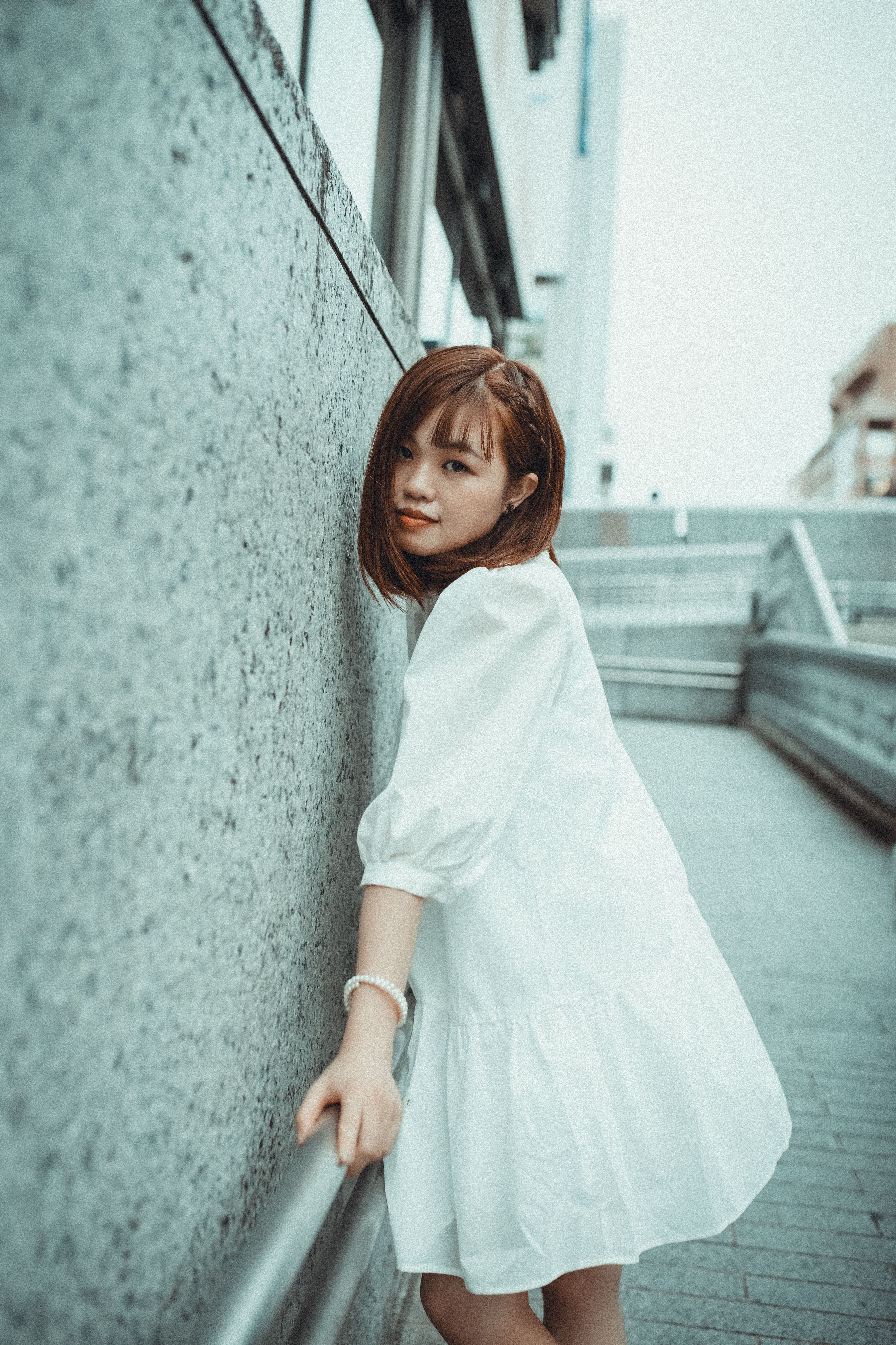 A Woman in a White Dress Leaning on a Metal Railing · Free Stock Photo