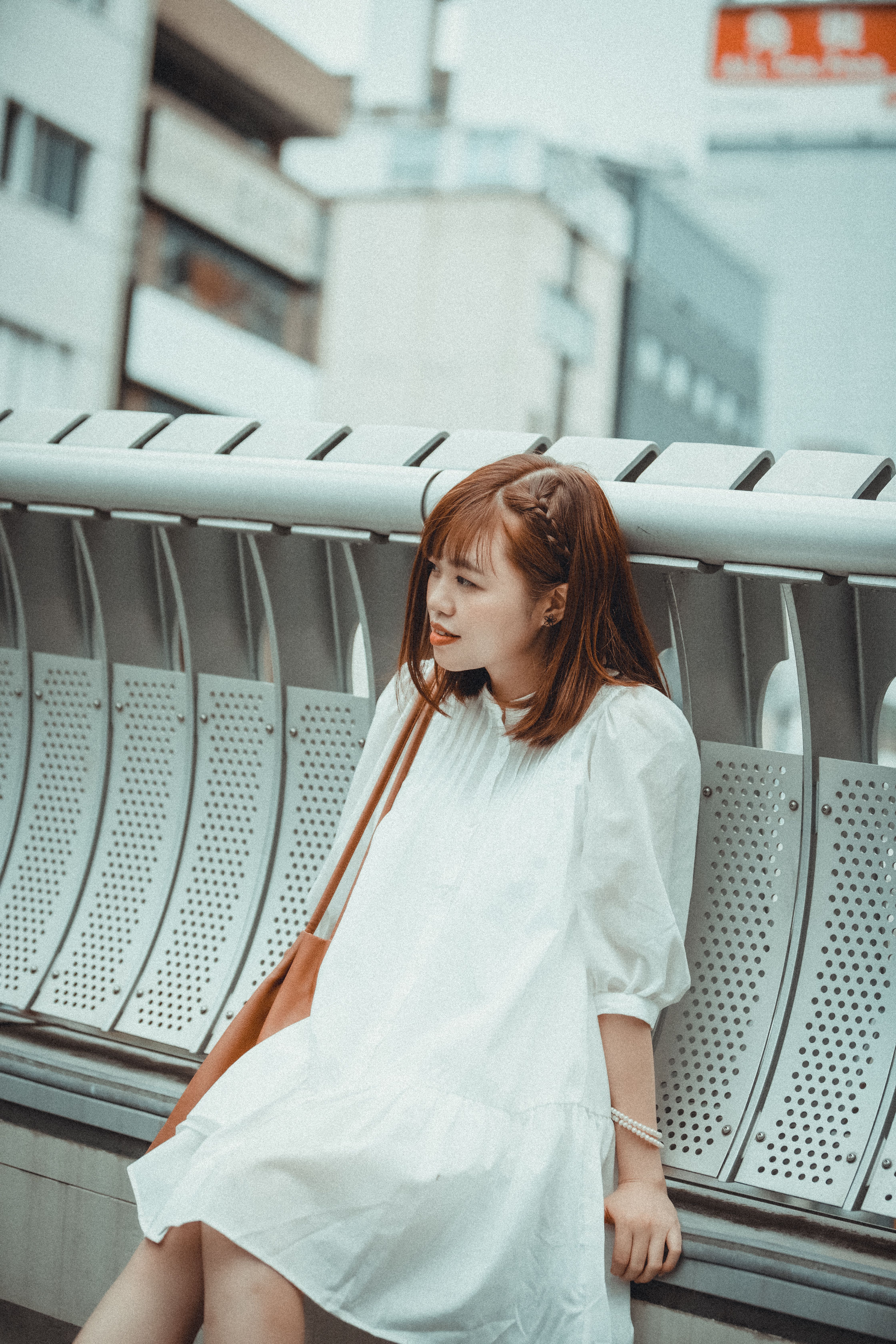 Woman in a White Dress Sitting on a Metal Railing · Free Stock Photo
