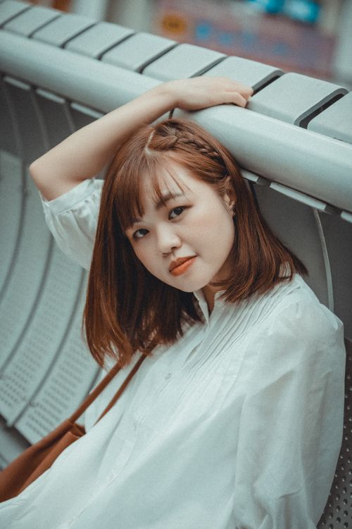 Free Young woman with long hair posing indoors by a metal handrail, exuding a stylish vibe. Stock Photo