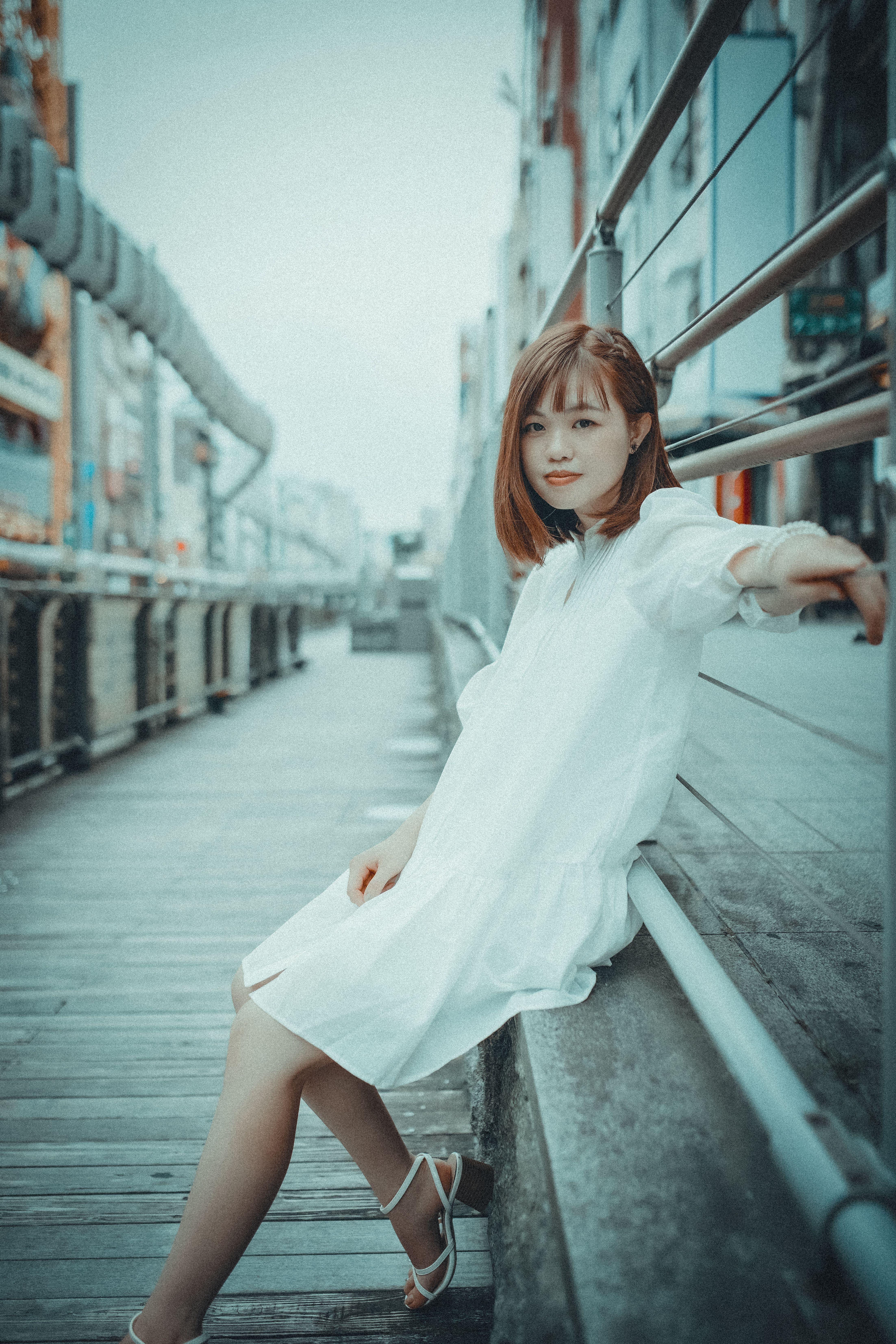A Woman in a White Dress Leaning on a Metal Railing · Free Stock Photo