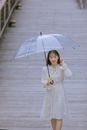Woman in White Long Sleeve Dress Holding Umbrella