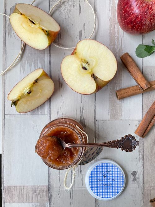 Free Delicious homemade apple jam with fresh apple slices and cinnamon sticks on a wooden table. Stock Photo