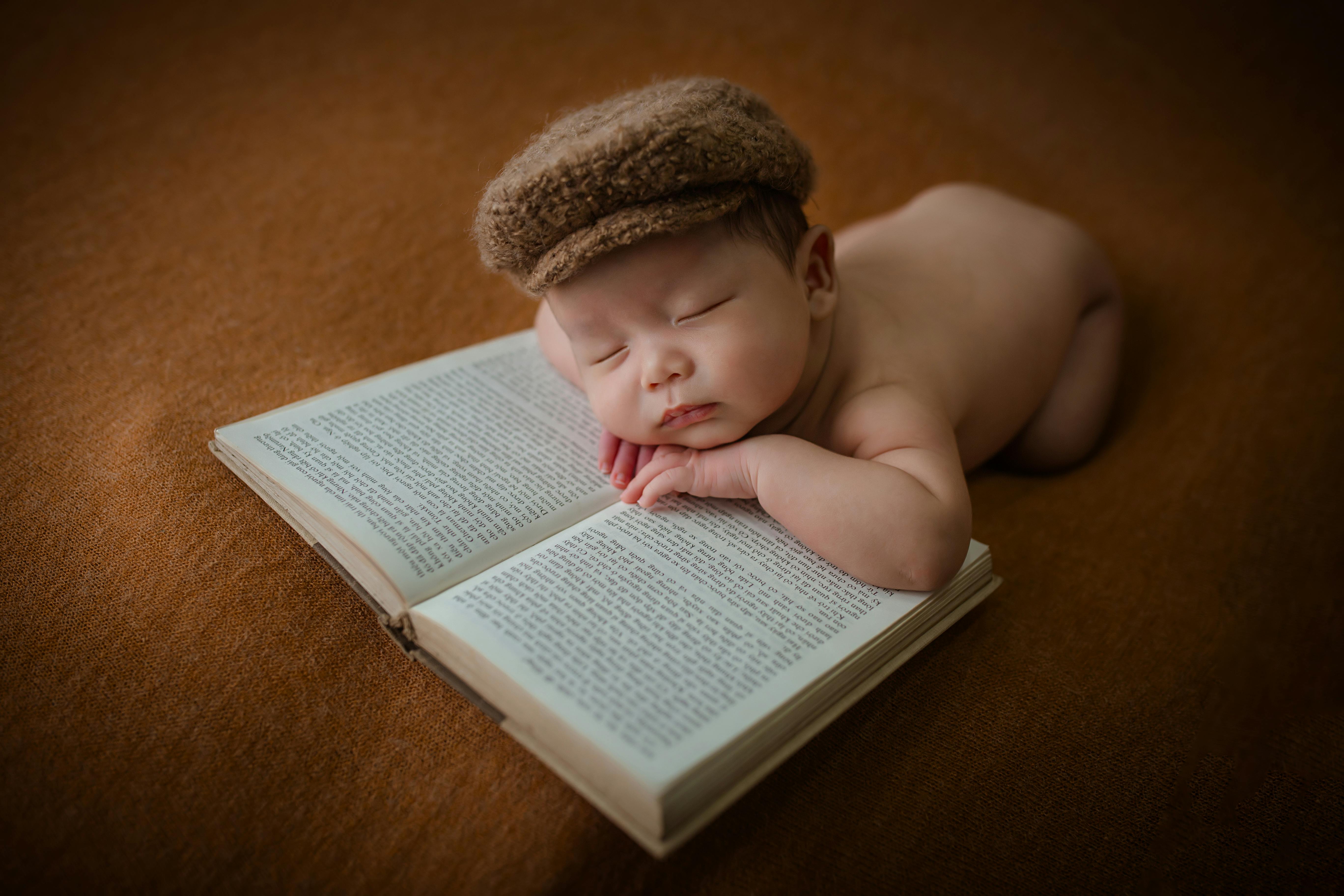 A Sleeping Baby Lying on an Open Book · Free Stock Photo