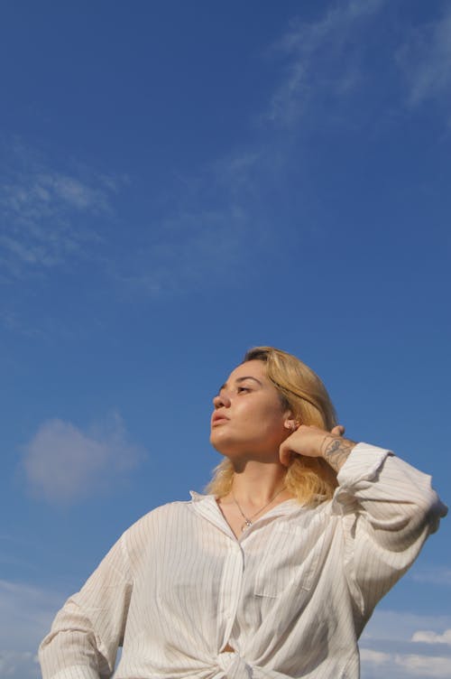Woman in Striped White Long Sleeves Under a Blue Sky