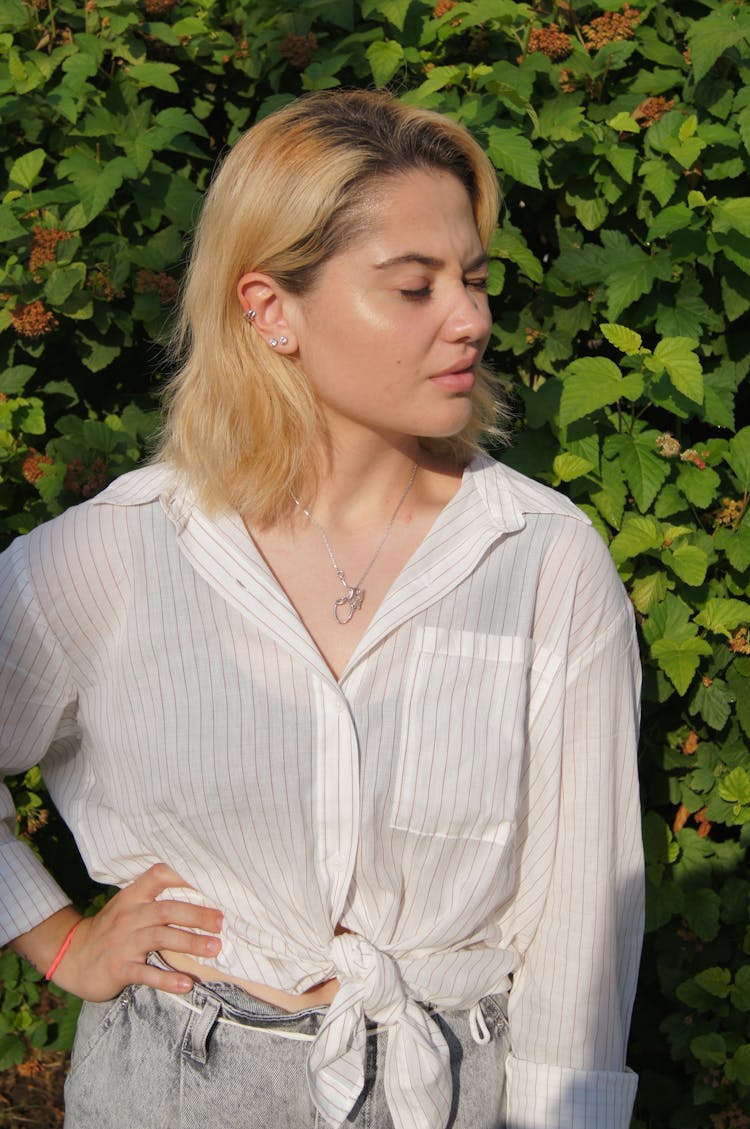 A Woman Wearing A White Shirt Squinting