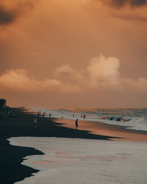 Foto profissional grátis de beira-mar, céu nublado, Hora dourada