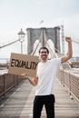 Man on Brooklyn Bridge Holding a Placard