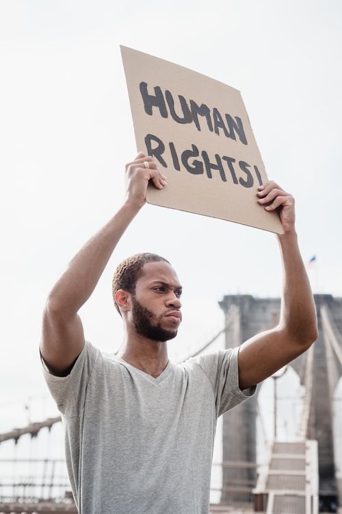 Photo of a Man Raising a Human Rights Signage · Free Stock Photo