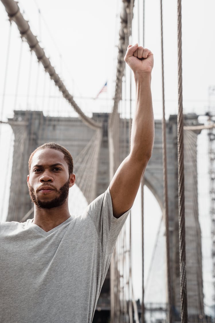 Man In A Gray Shirt Raising His Fist