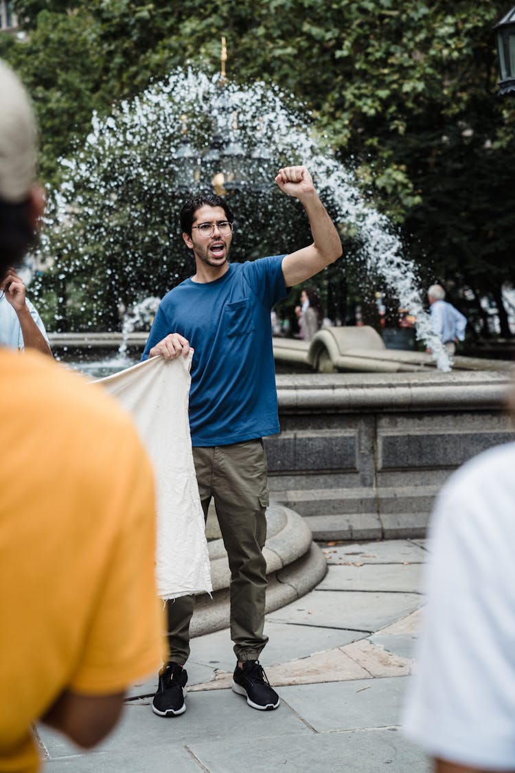 Man In A Blue Shirt Raising His Fist