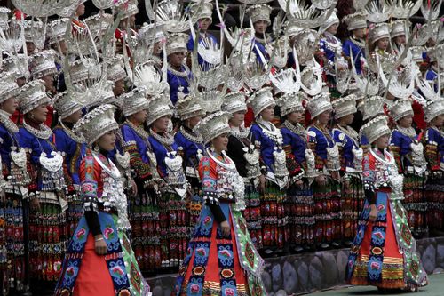 Free Group of women in traditional Chinese attire during a cultural ceremony, showcasing intricate silver headdresses and colorful garments. Stock Photo
