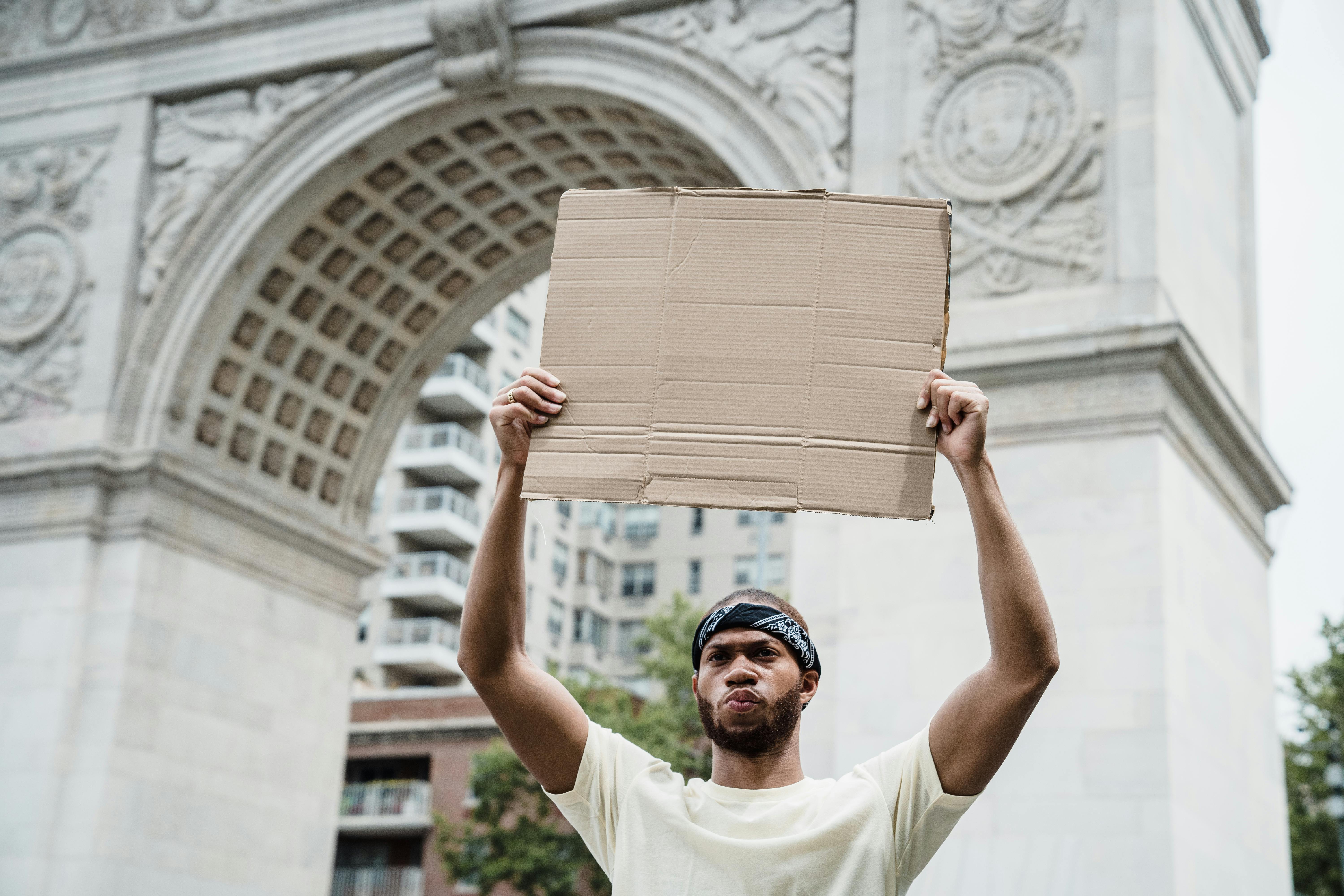 a man holding a placard near the washington square arch