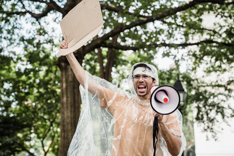 A Man Protesting While Wearing A Transparent Raincoat