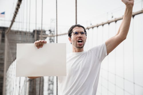 Man with Poster Screaming on Demonstration on Bridge