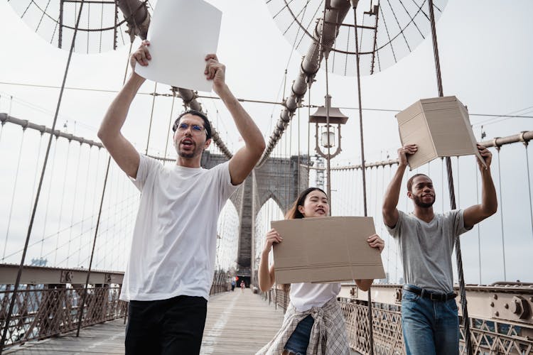 People With Mockup Placards Walking On Bridge