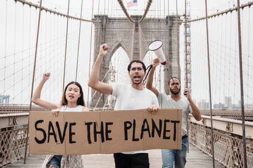 Free Protesters with banners and megaphones demanding environmental action on Brooklyn Bridge, New York. Stock Photo