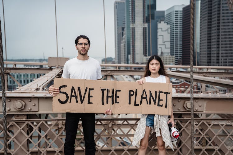 Man And Woman Holding A Cardboard Placard