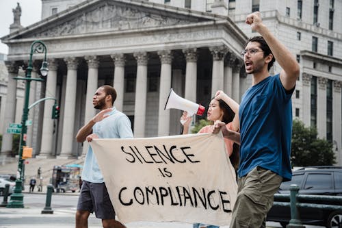 People Carrying a Banner and Shouting on a Protest 