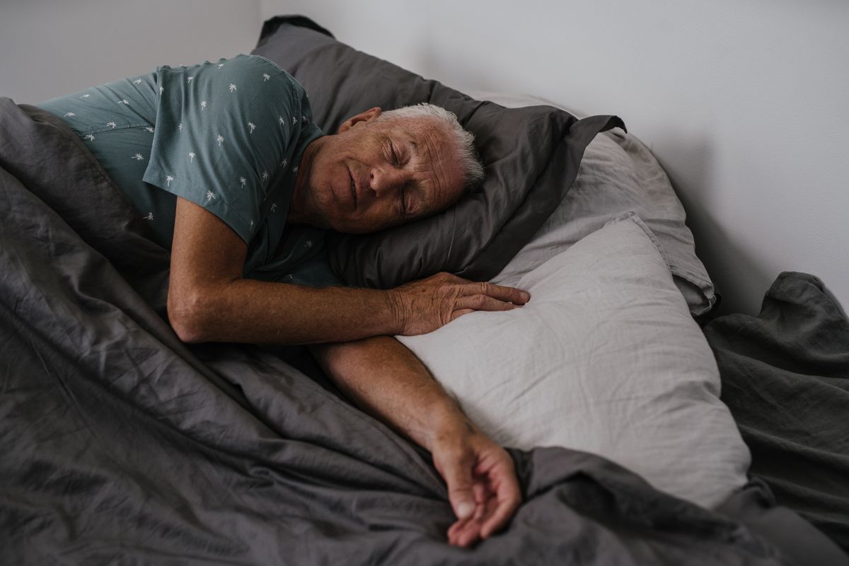 Older man resting comfortably in bed in a calm room