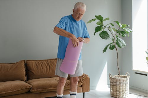 A Man in Blue Crew Neck T-shirt Holding a Yoga Mat