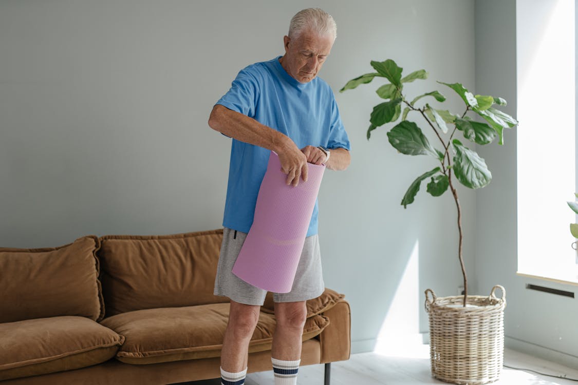 A Man in Blue Crew Neck T-shirt Holding a Yoga Mat