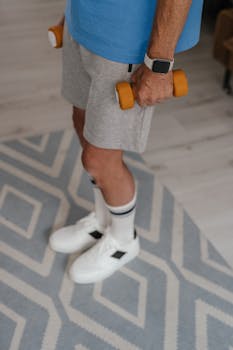A senior adult holding dumbbells while exercising indoors, promoting a healthy lifestyle.