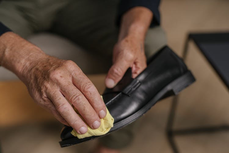 A Person Polishing A Shoe