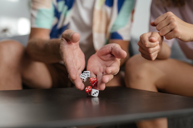 A Person Holding A Red And White Dices