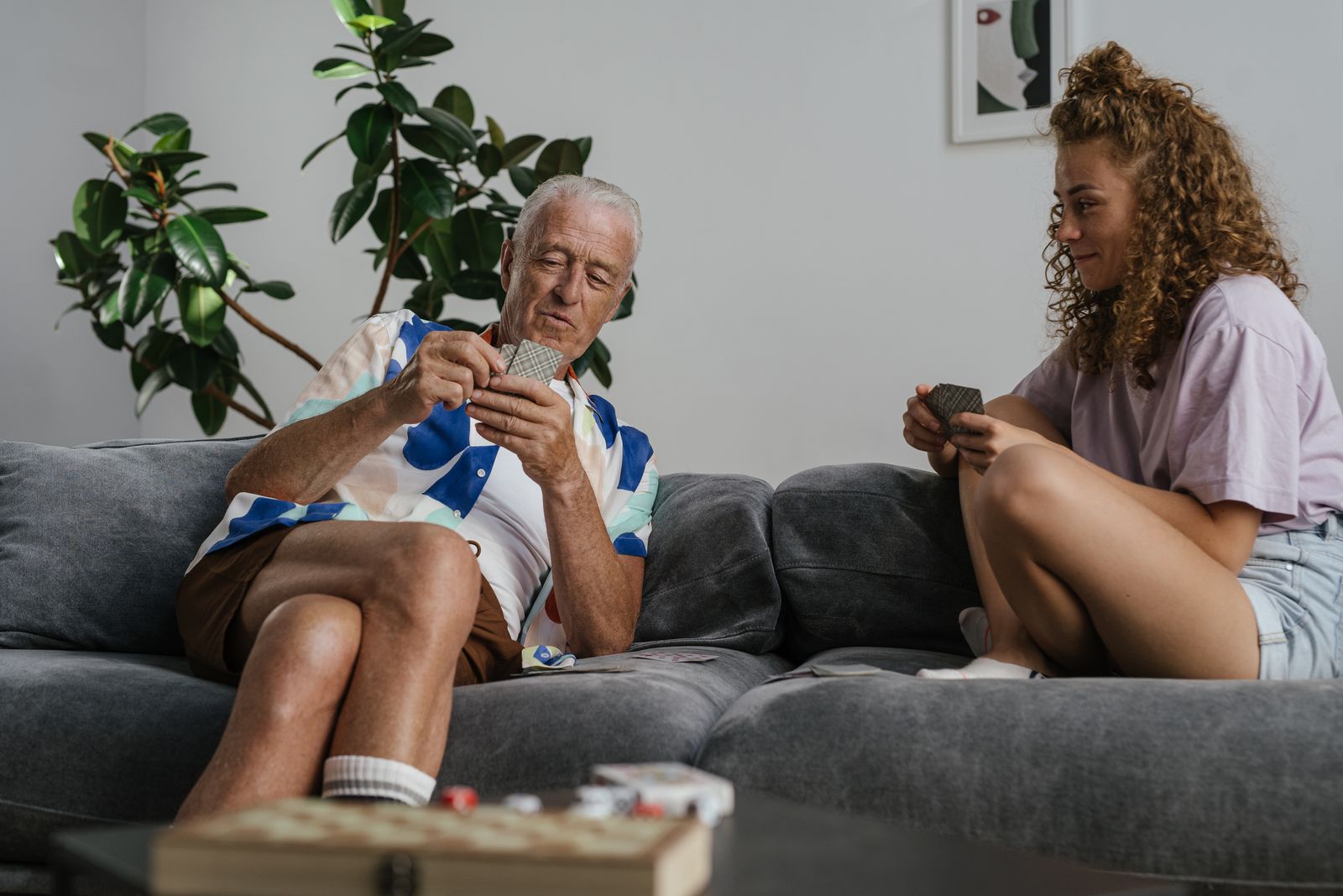 Un homme âgé et une jeune femme jouent aux cartes ensemble