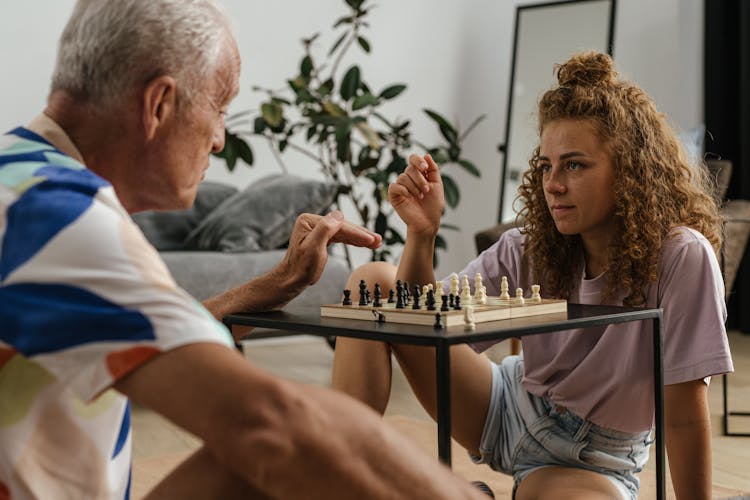 Elderly Man And A Woman Playing Chess