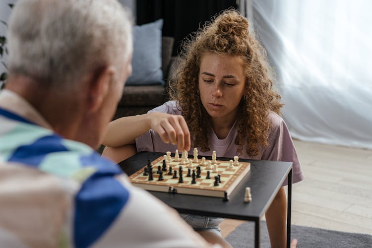 Grandpa And Granddaughter Playing Chess