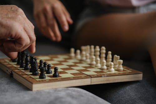 Person Playing Chess on Chess Board