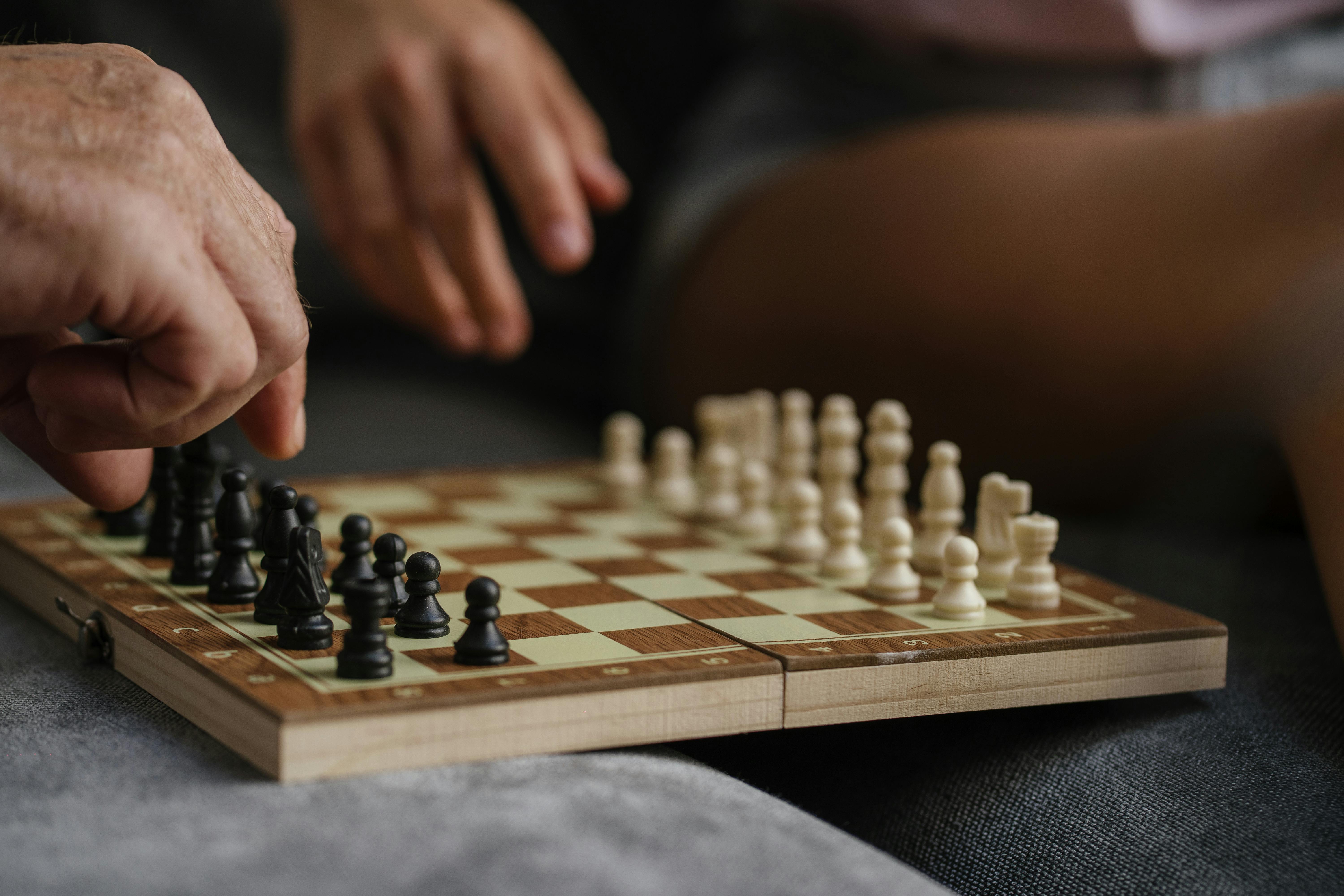 Download A Person Is Playing Chess On A Board Wallpaper